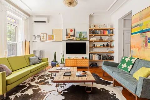 a living room with furniture flat screen tv and a large window