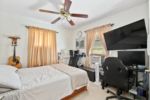 a bedroom with bed tv and window