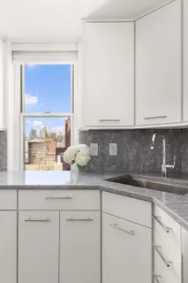 a kitchen with granite countertop white cabinets and a window