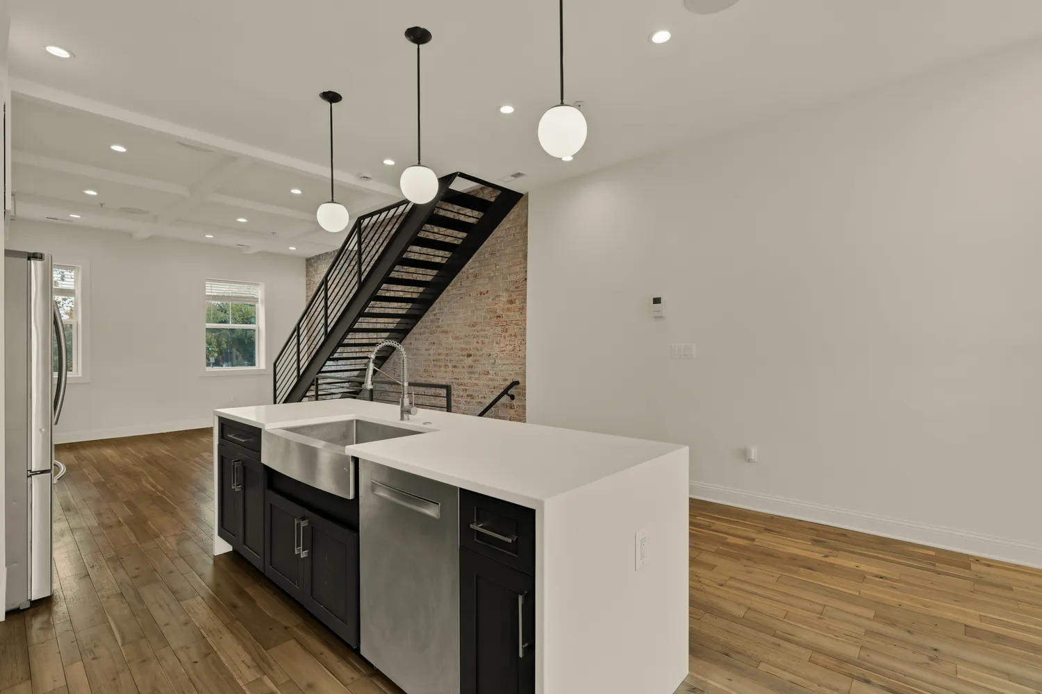 a kitchen with a sink a stove and wooden floor