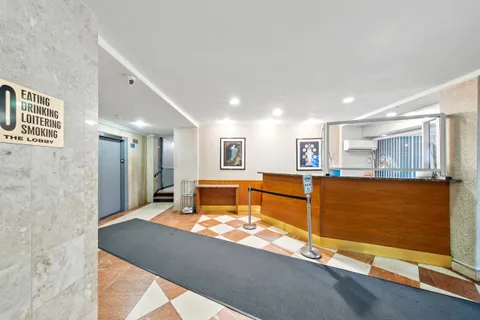 a living room with stainless steel appliances kitchen island granite countertop a refrigerator and a cabinets