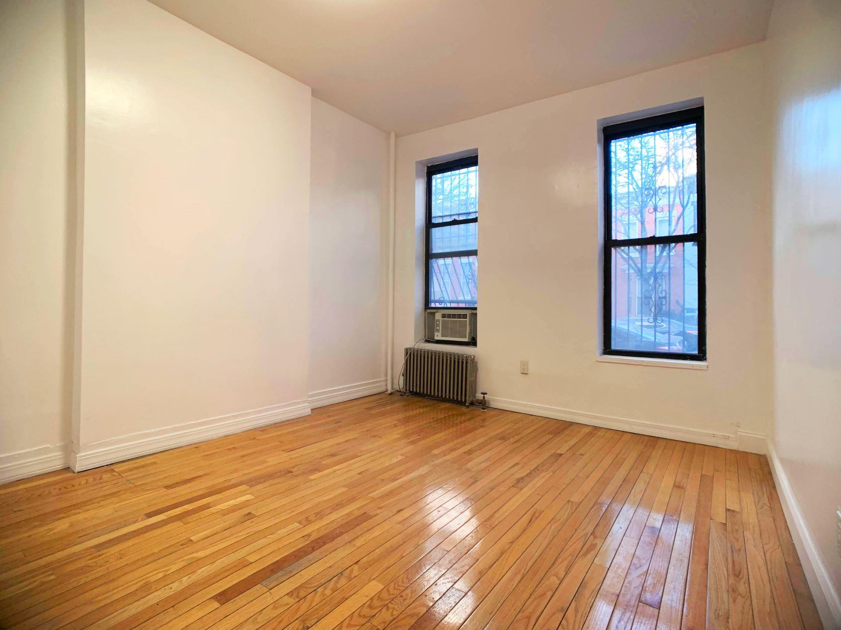 630 President Street, Unit 1 Brooklyn, NY 11215 - Photo 4 of 11 an empty room with wooden floor and windows