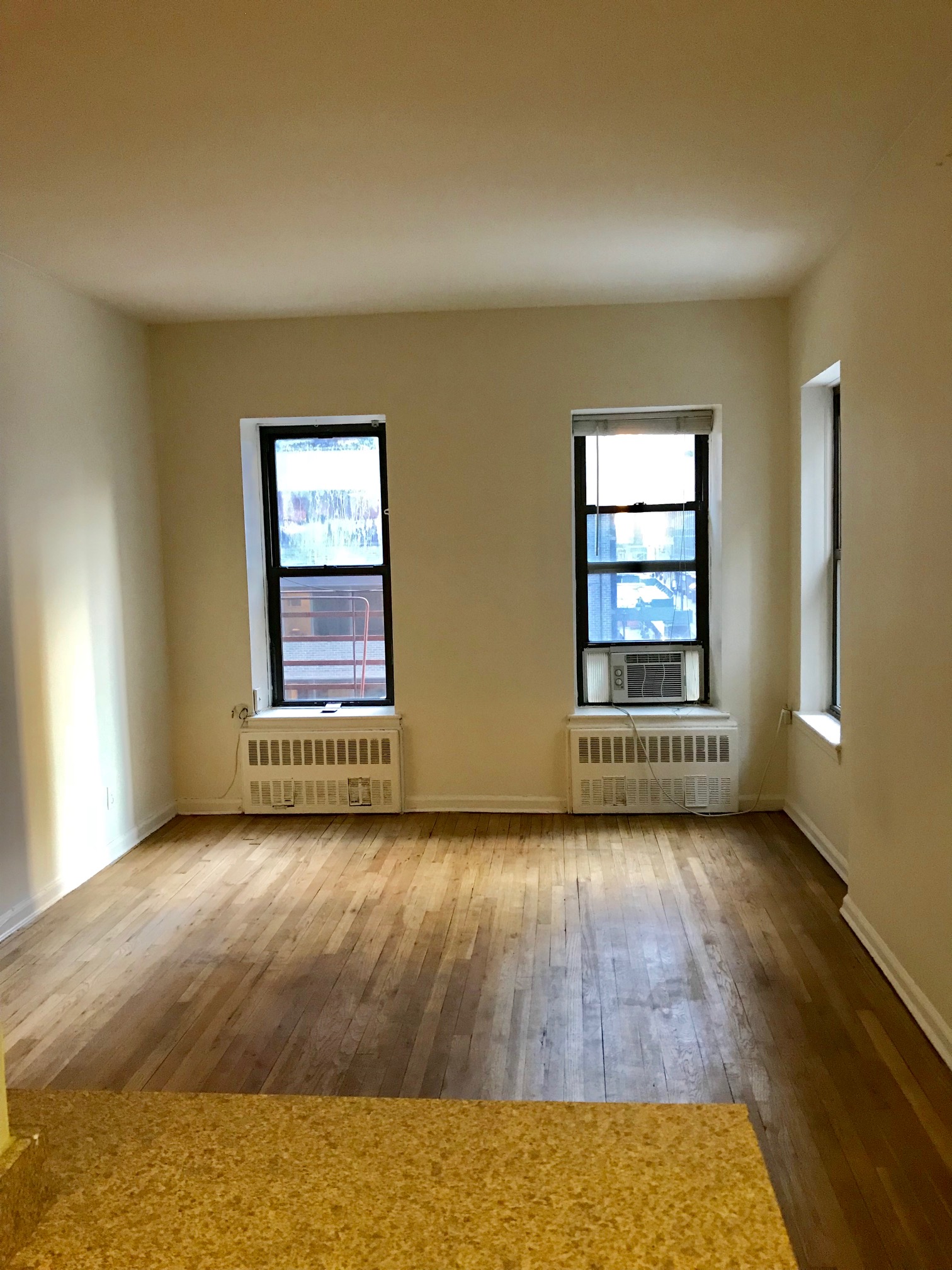 153 East 43rd Street, Unit 5A Manhattan, NY 10017 - Photo 7 of 7 an empty room with wooden floor and windows