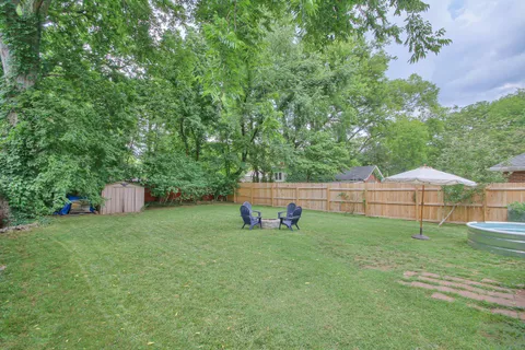 a backyard of a house with table and chairs