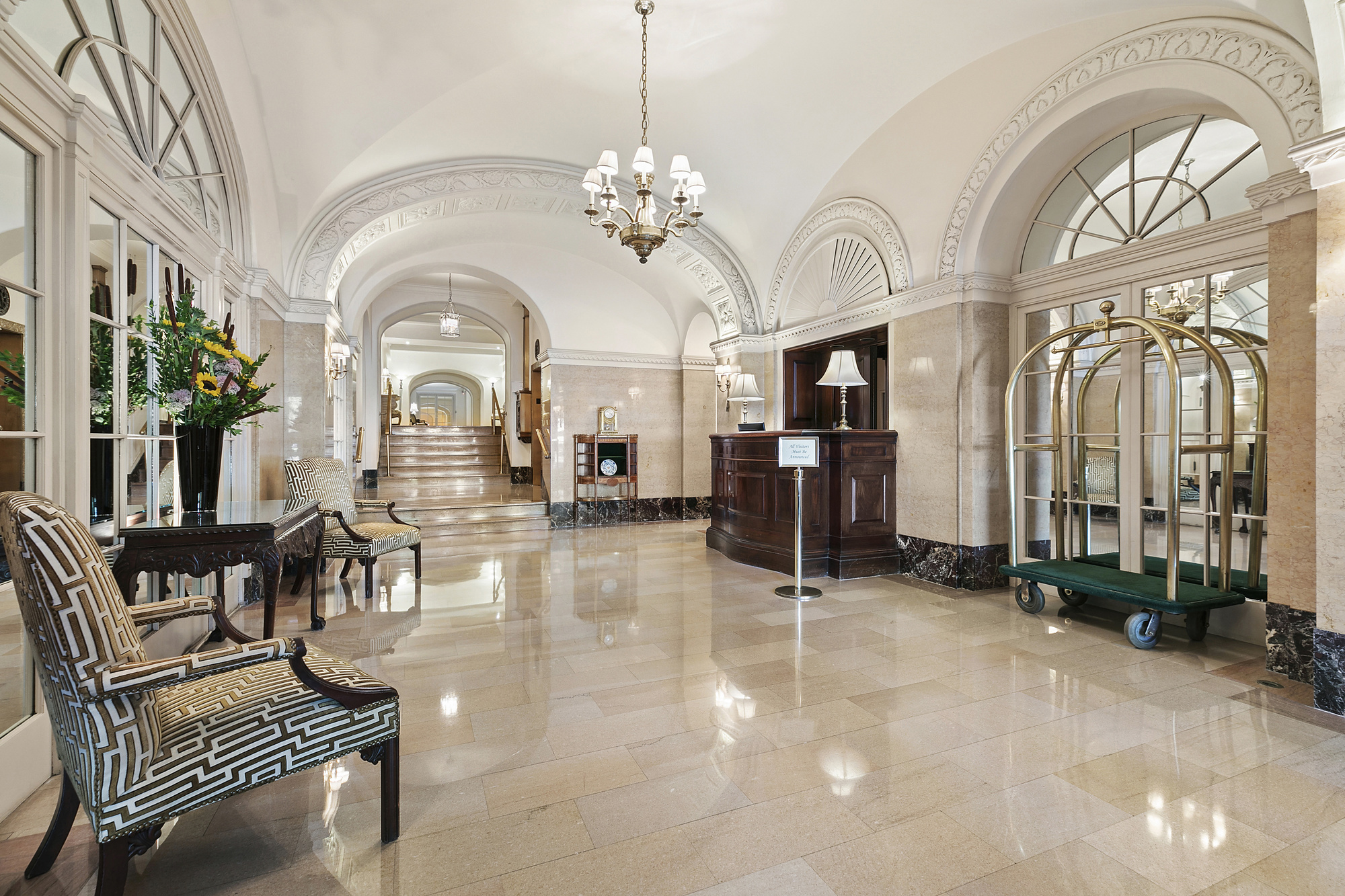575 Park Avenue, Unit 1403 Manhattan, NY 10065 - Photo 12 of 15 a living room with fireplace furniture and a chandelier