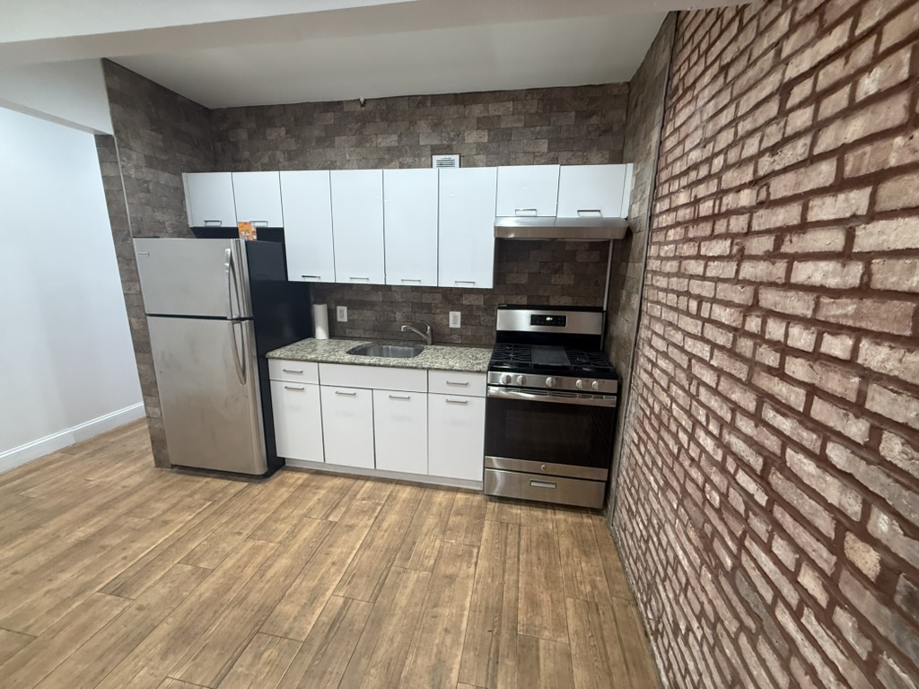 613 Marcy Avenue, Unit 1B Brooklyn, NY 11206 - Photo 8 of 8 a kitchen with a sink a refrigerator and cabinets