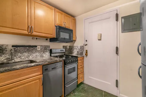 a kitchen with stainless steel appliances granite countertop a refrigerator and a stove top oven