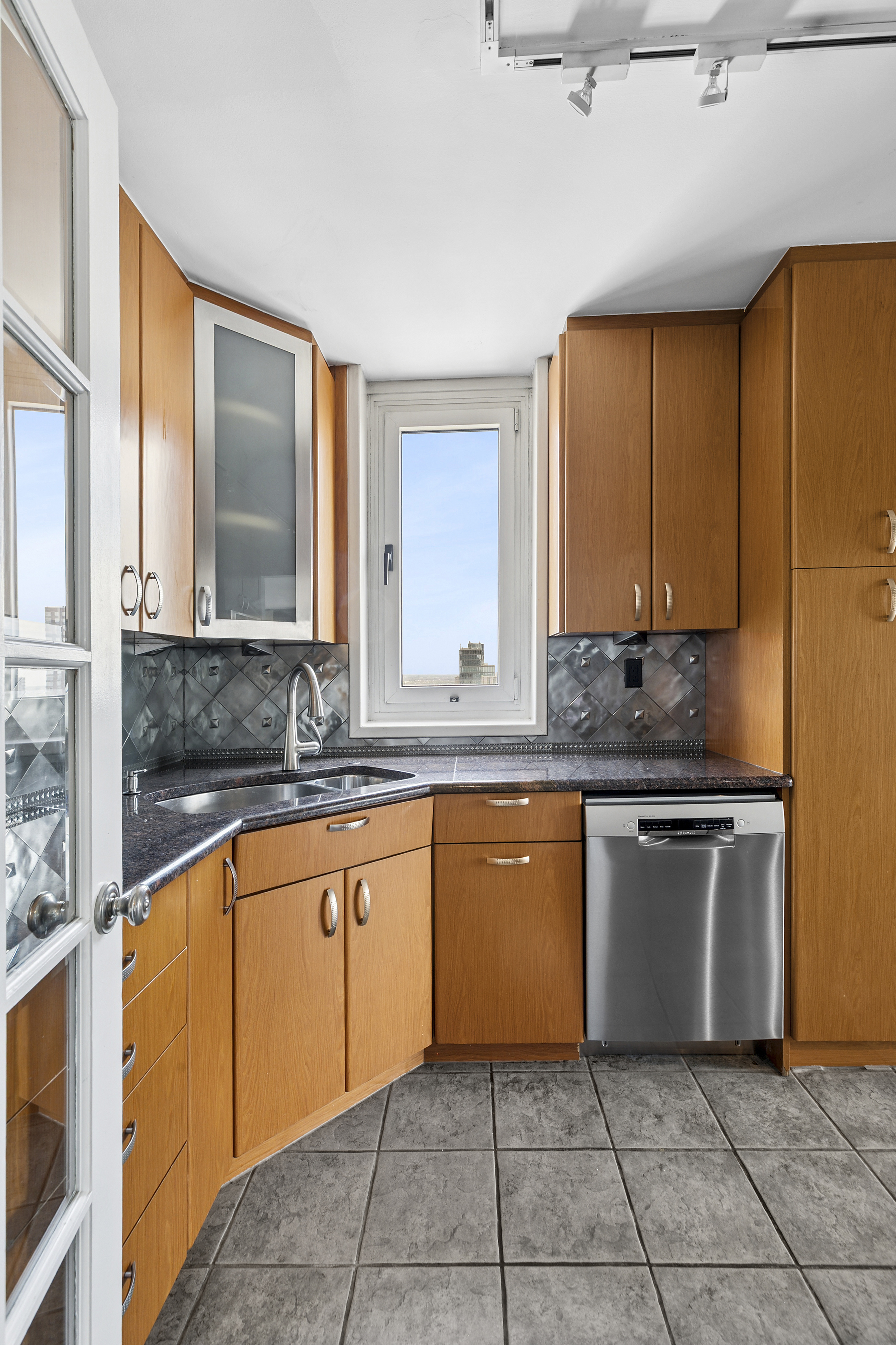 200 East 89th Street, Unit 34CD Manhattan, NY 10128 - Photo 5 of 20 a kitchen with stainless steel appliances granite countertop a sink and cabinets