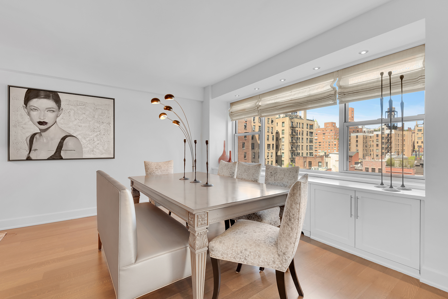 150 East 69th Street, Unit 8J Manhattan, NY 10021 - Photo 2 of 13 a view of a dining room with furniture a chandelier and wooden floor