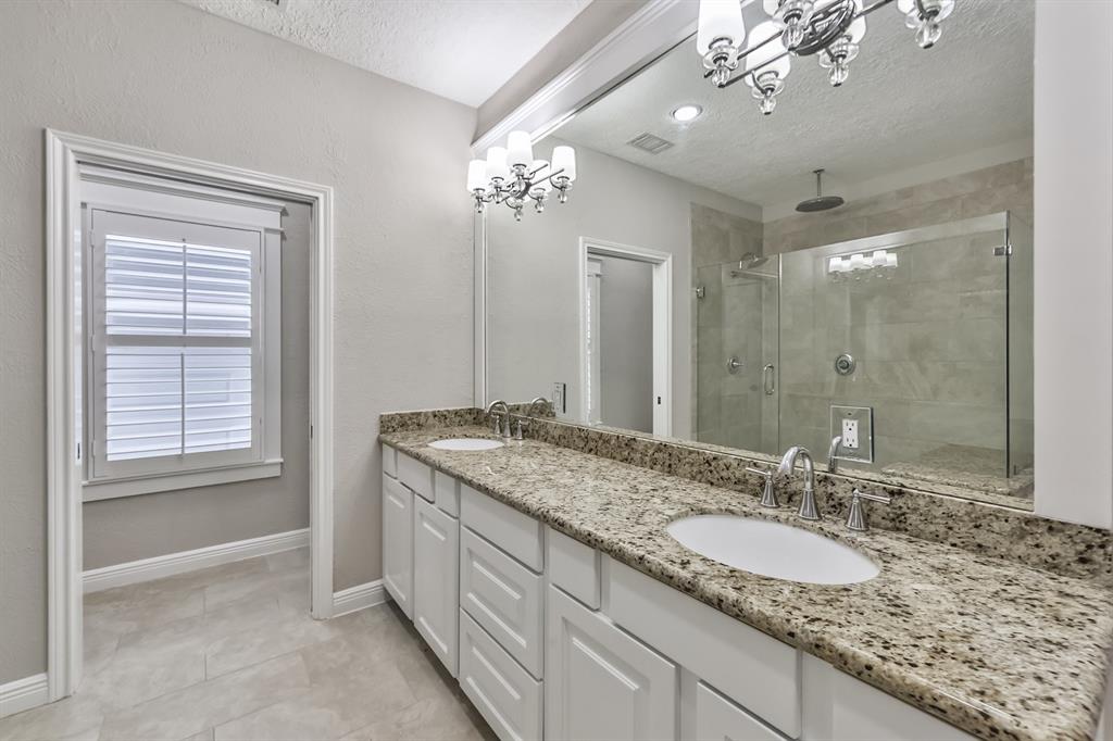 1120 Winston Street Houston, TX 77009 - Photo 21 of 29 a bathroom with a granite countertop sink a large mirror and a shower