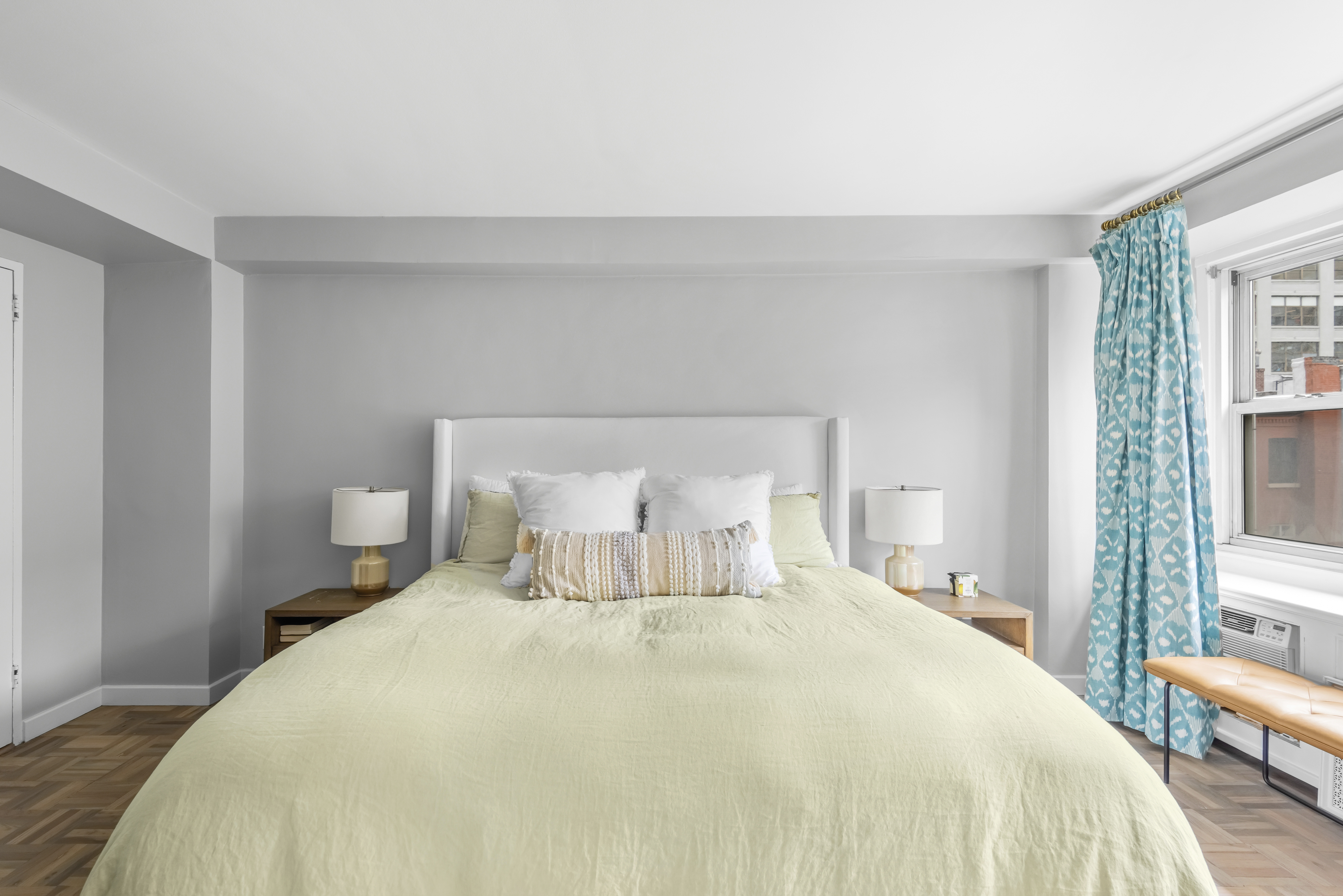 2 Charlton Street, Unit 5A Manhattan, NY 10014 - Photo 7 of 12 a large bed sitting in a bedroom next to a window and a lamp