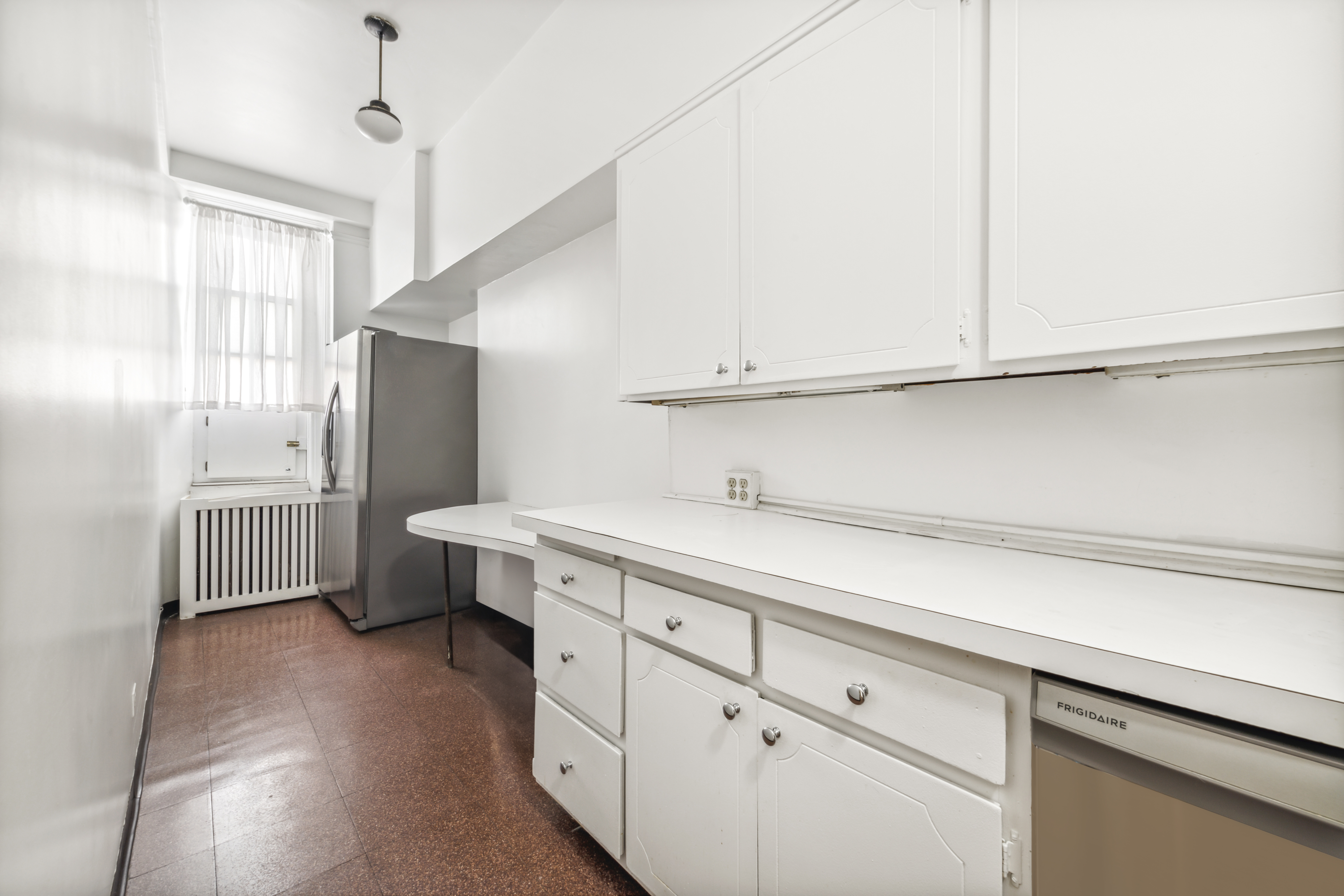 130 East 67th Street, Unit 9C Manhattan, NY 10065 - Photo 9 of 20 a kitchen with stainless steel appliances a refrigerator and cabinets