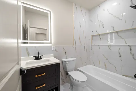 a bathroom with a sink toilet vanity and shower