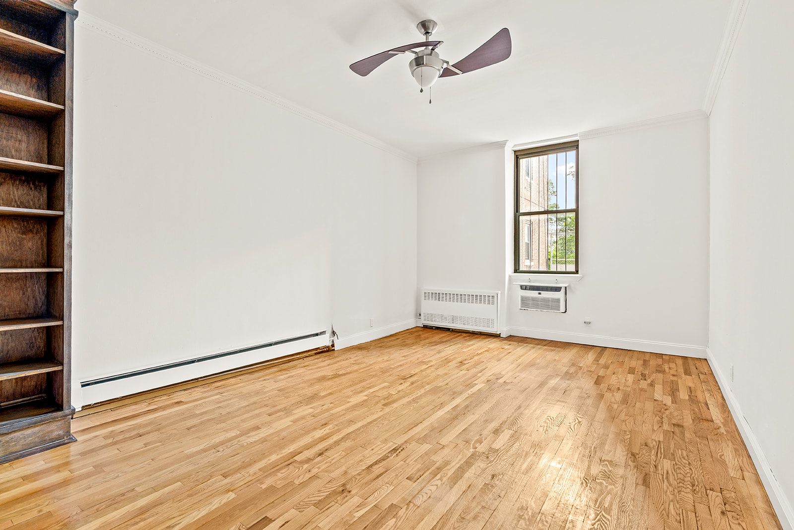 689 Fort Washington Avenue, Unit 1AA Manhattan, NY 10040 - Photo 7 of 13 an empty room with wooden floor closet and windows