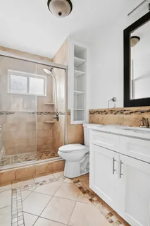 a bathroom with a granite countertop sink mirror vanity and toilet