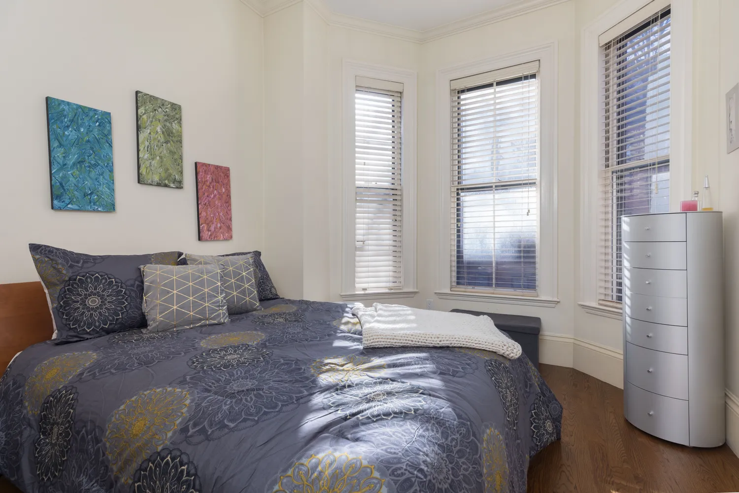 a large bed sitting in a bedroom next to a window