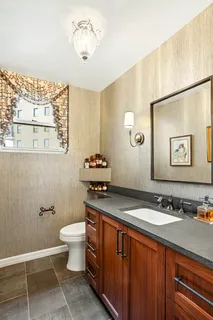 a bathroom with a granite countertop sink a toilet and a mirror