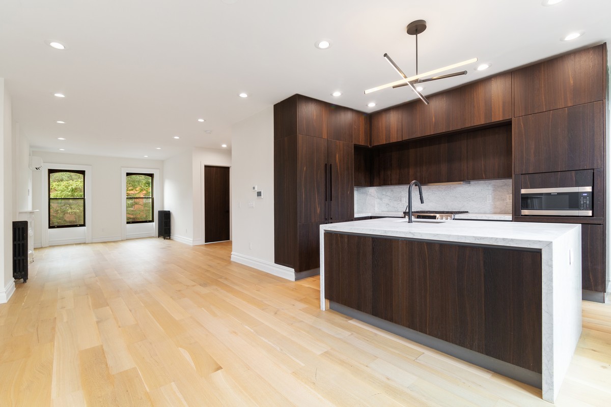 a kitchen with kitchen island a sink stainless steel appliances and cabinets