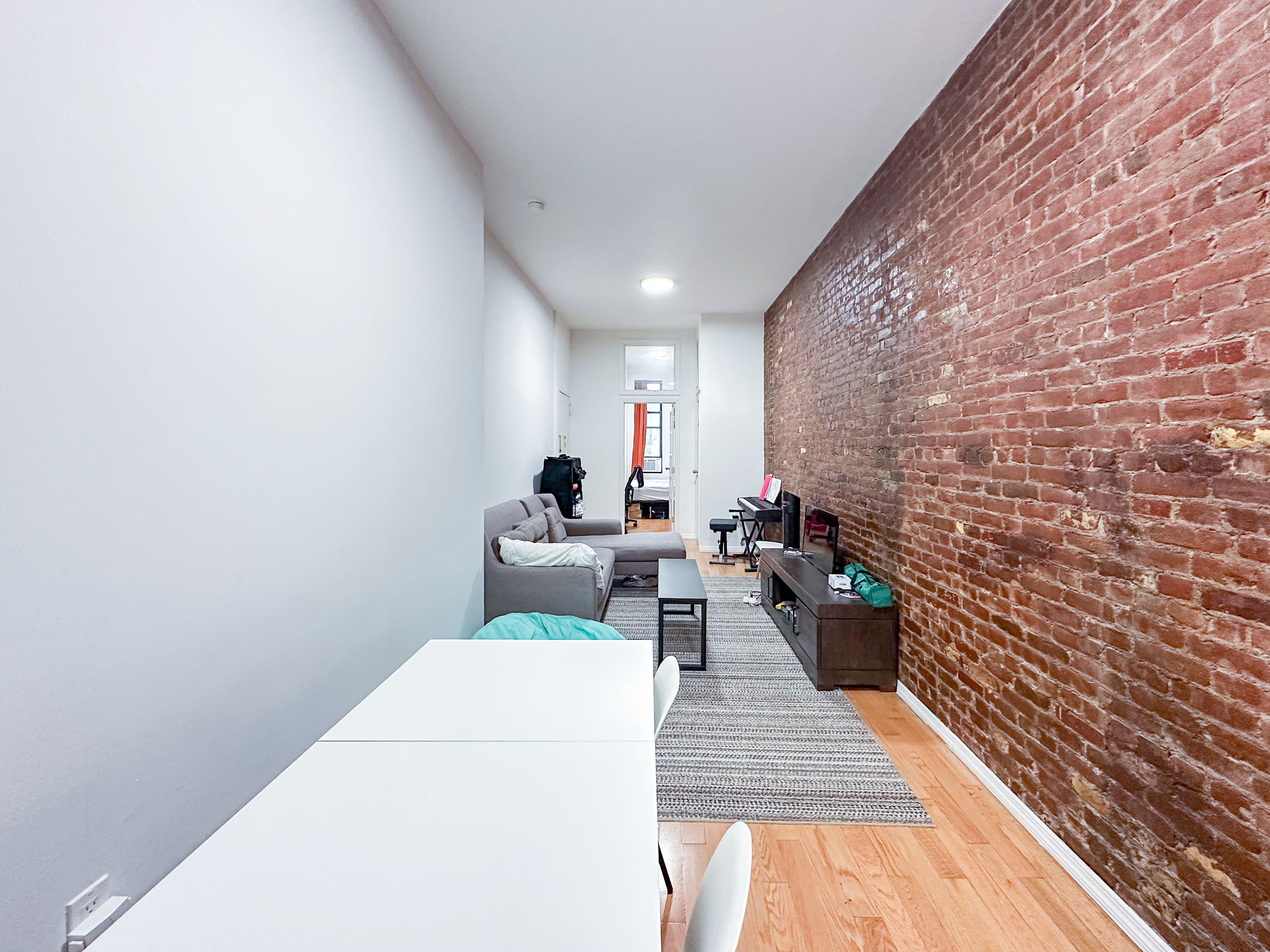 213 East 5th Street, Unit 1 Manhattan, NY 10003 - Photo 2 of 18 a view of a hallway with couch and wooden floor