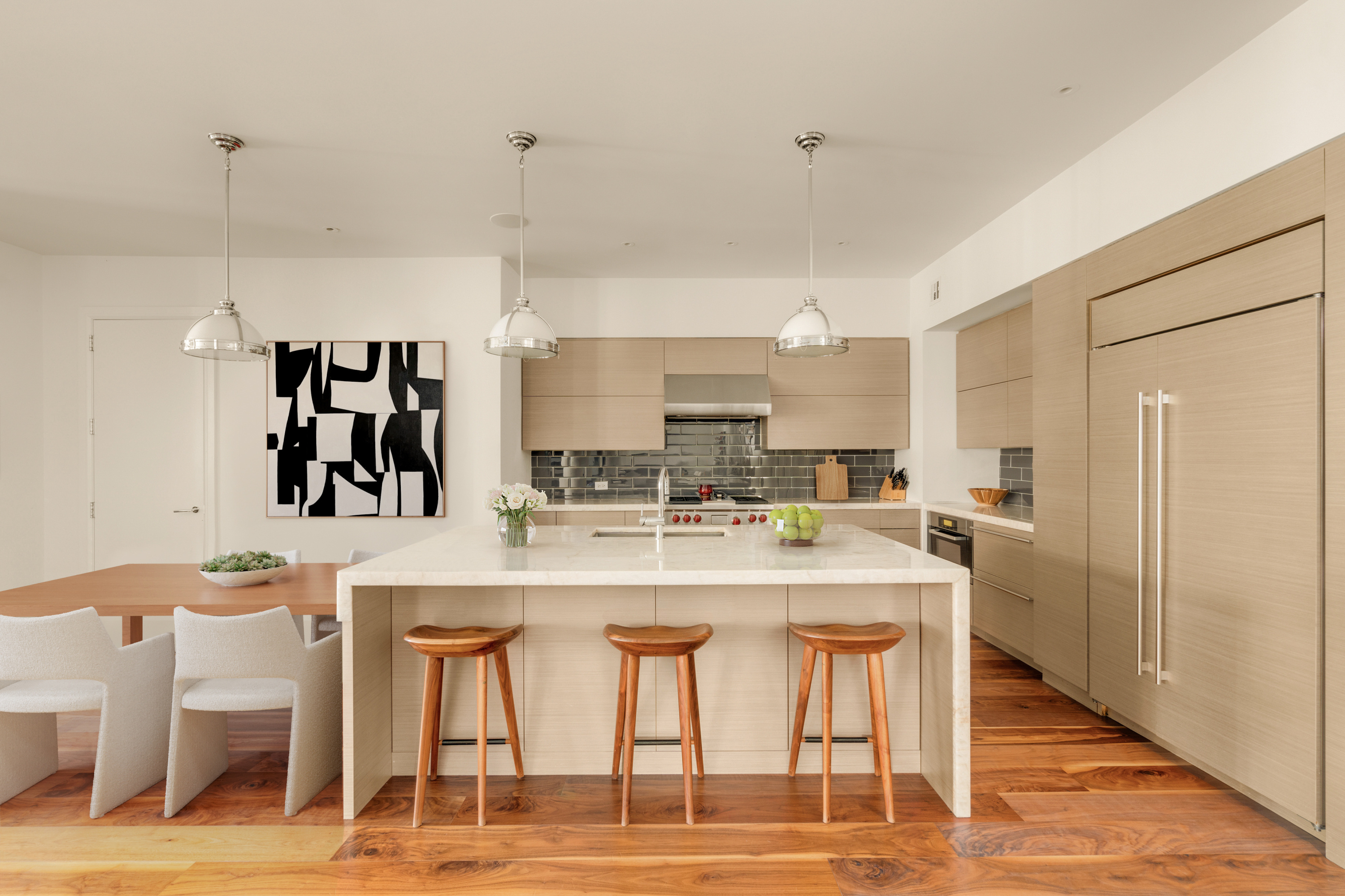 60 Beach Street, Unit 3C Manhattan, NY 10013 - Photo 4 of 12 a kitchen with stainless steel appliances kitchen island granite countertop a table and chairs in it