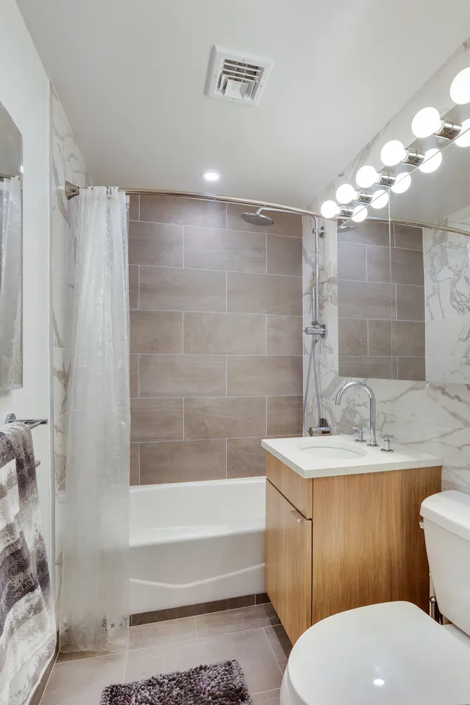 a bathroom with a sink toilet double vanity and bathtub