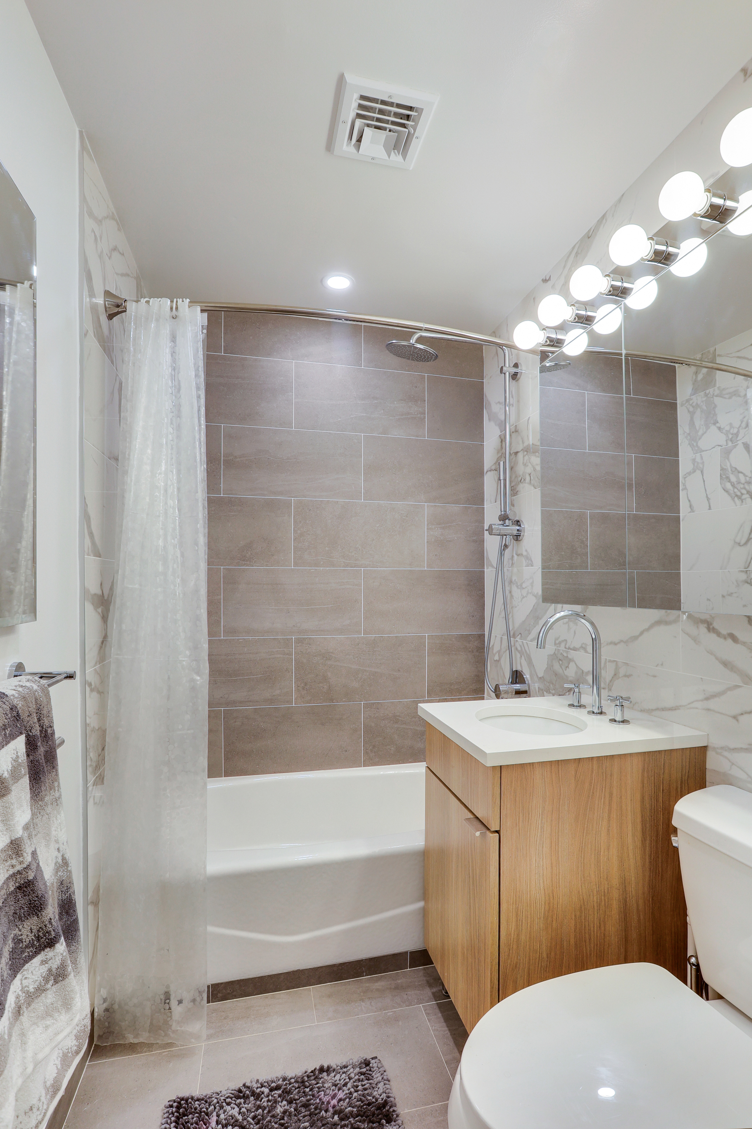 310 East 46th Street, Unit 20H Manhattan, NY 10017 - Photo 7 of 9 a bathroom with a sink toilet double vanity and bathtub