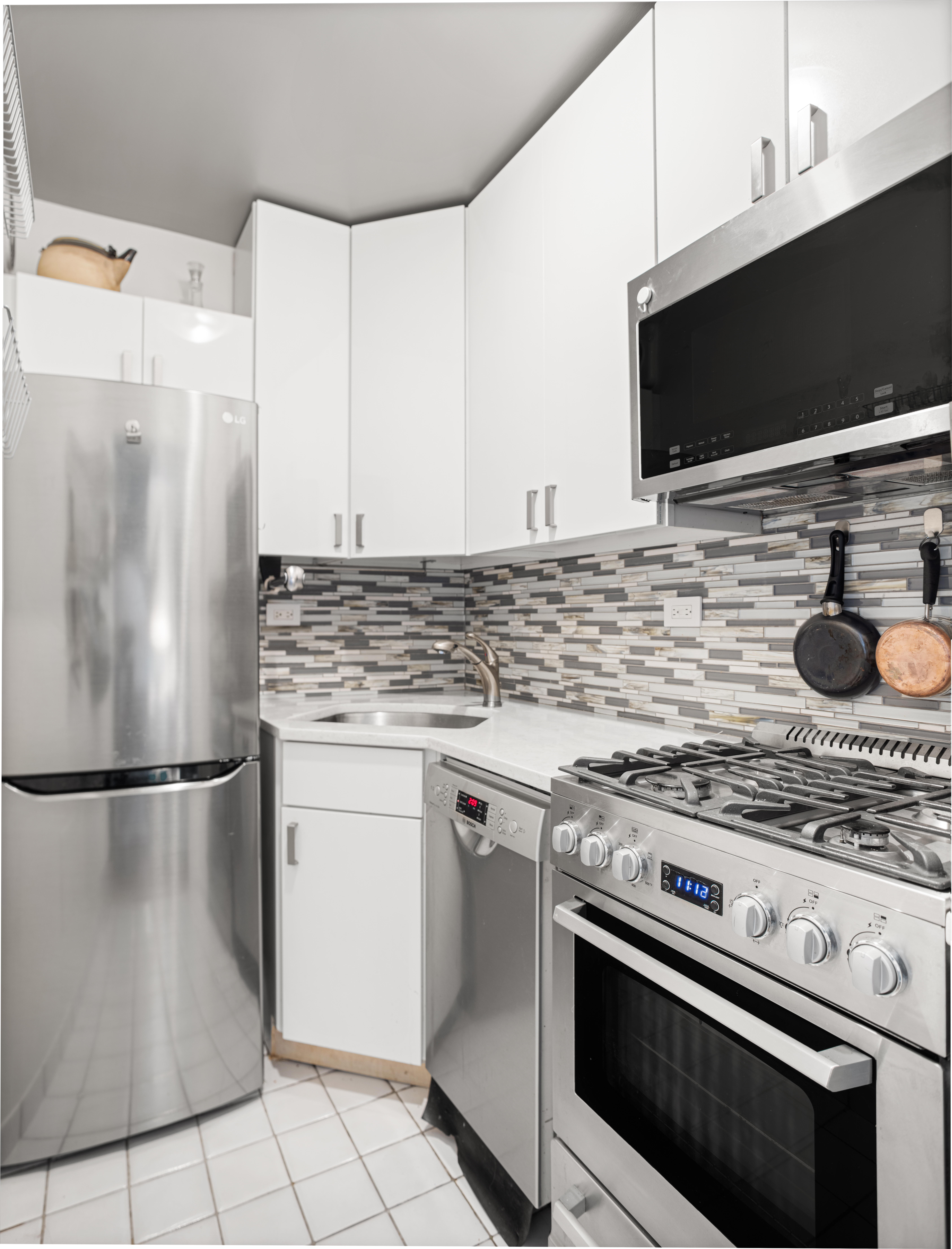 101 West 12th Street, Unit 9D Manhattan, NY 10011 - Photo 3 of 8 a kitchen with cabinets and steel stainless steel appliances