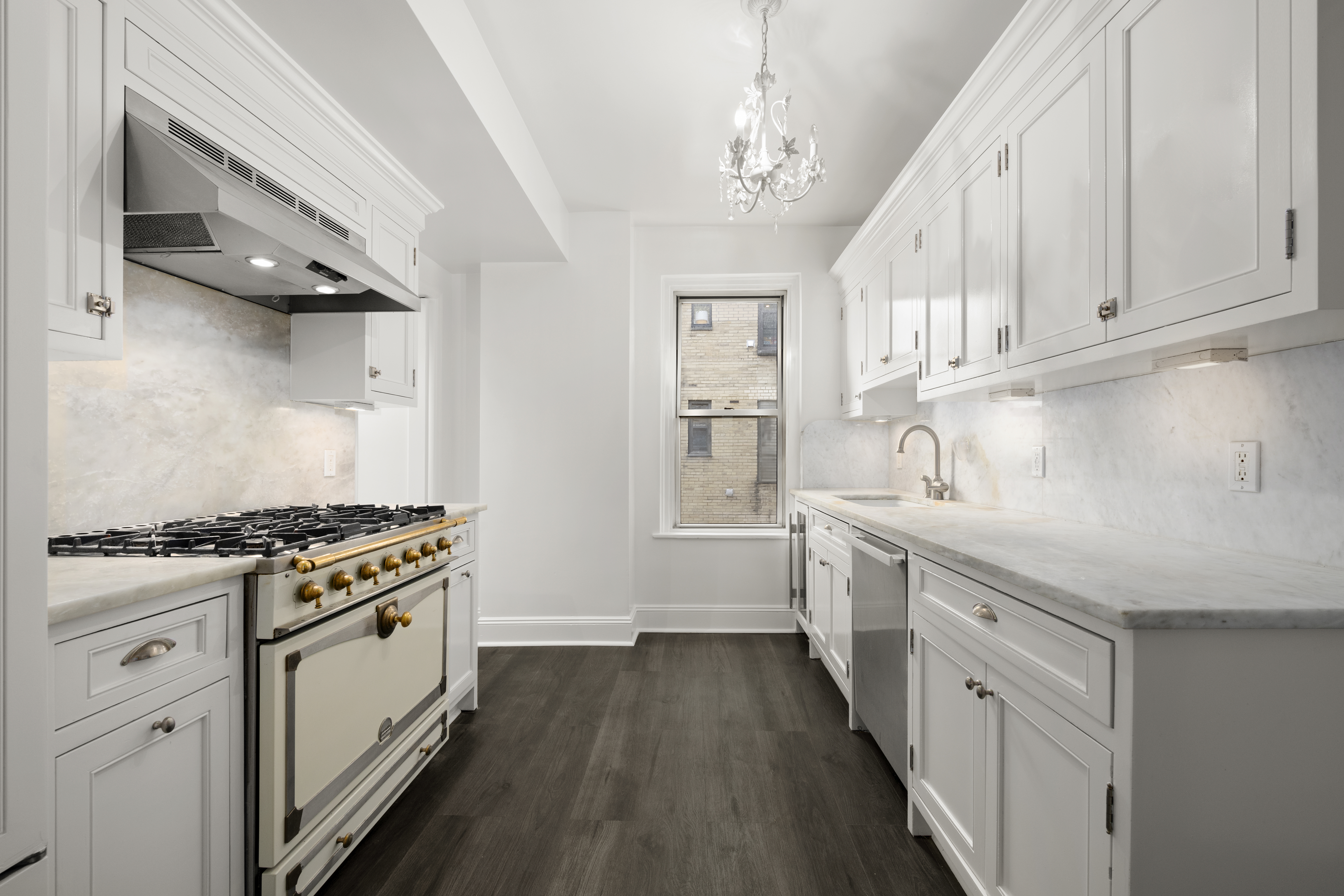 110-118 Riverside Drive, Unit 15C Manhattan, NY 10024 - Photo 4 of 6 a kitchen with white cabinets and appliances