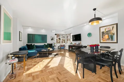 a living room with furniture a flat screen tv and kitchen view