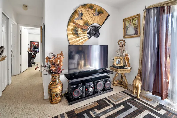 a bedroom with bed a flat tv screen and dresser
