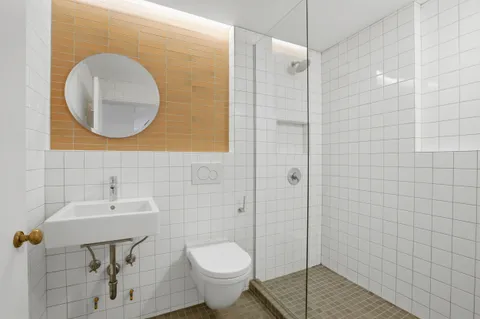 a bathroom with a toilet sink and mirror