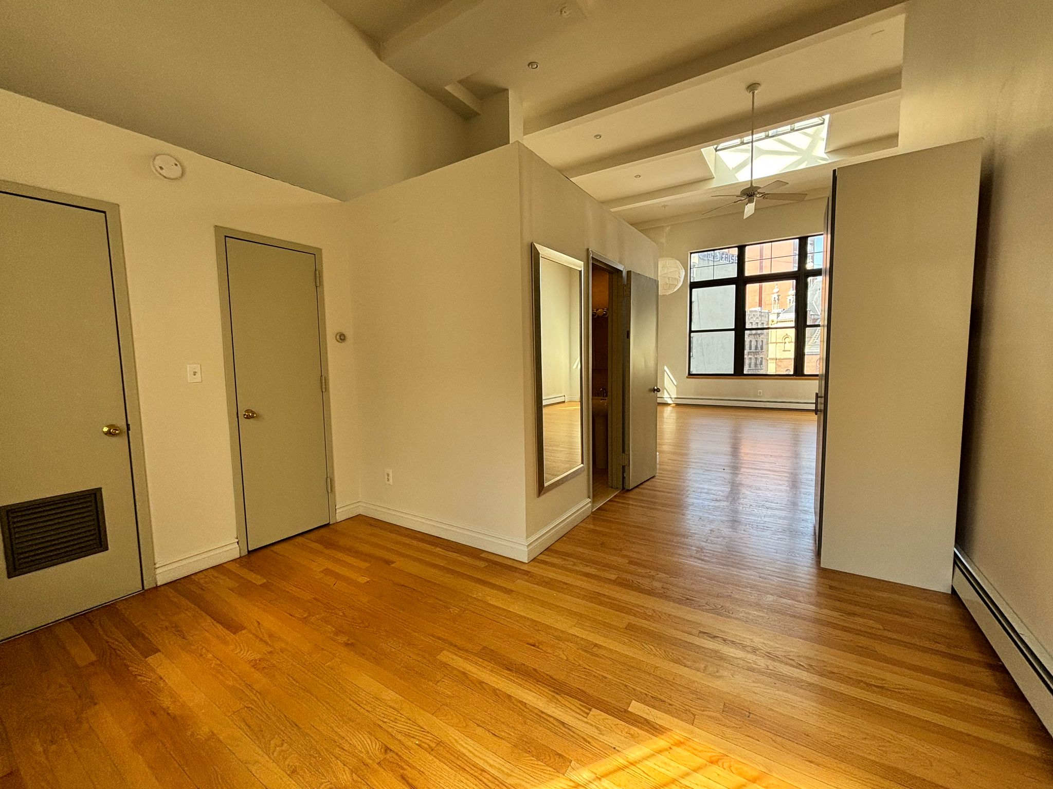 85 Division Street, Unit 4 Manhattan, NY 10002 - Photo 11 of 22 a view of empty room with wooden floor and fan