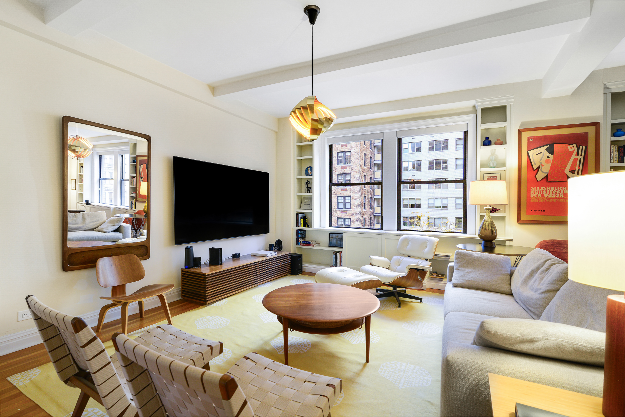 20 West 72nd Street, Unit 601 Manhattan, NY 10023 - Photo 1 of 21 a living room with furniture a flat screen tv and a chandelier