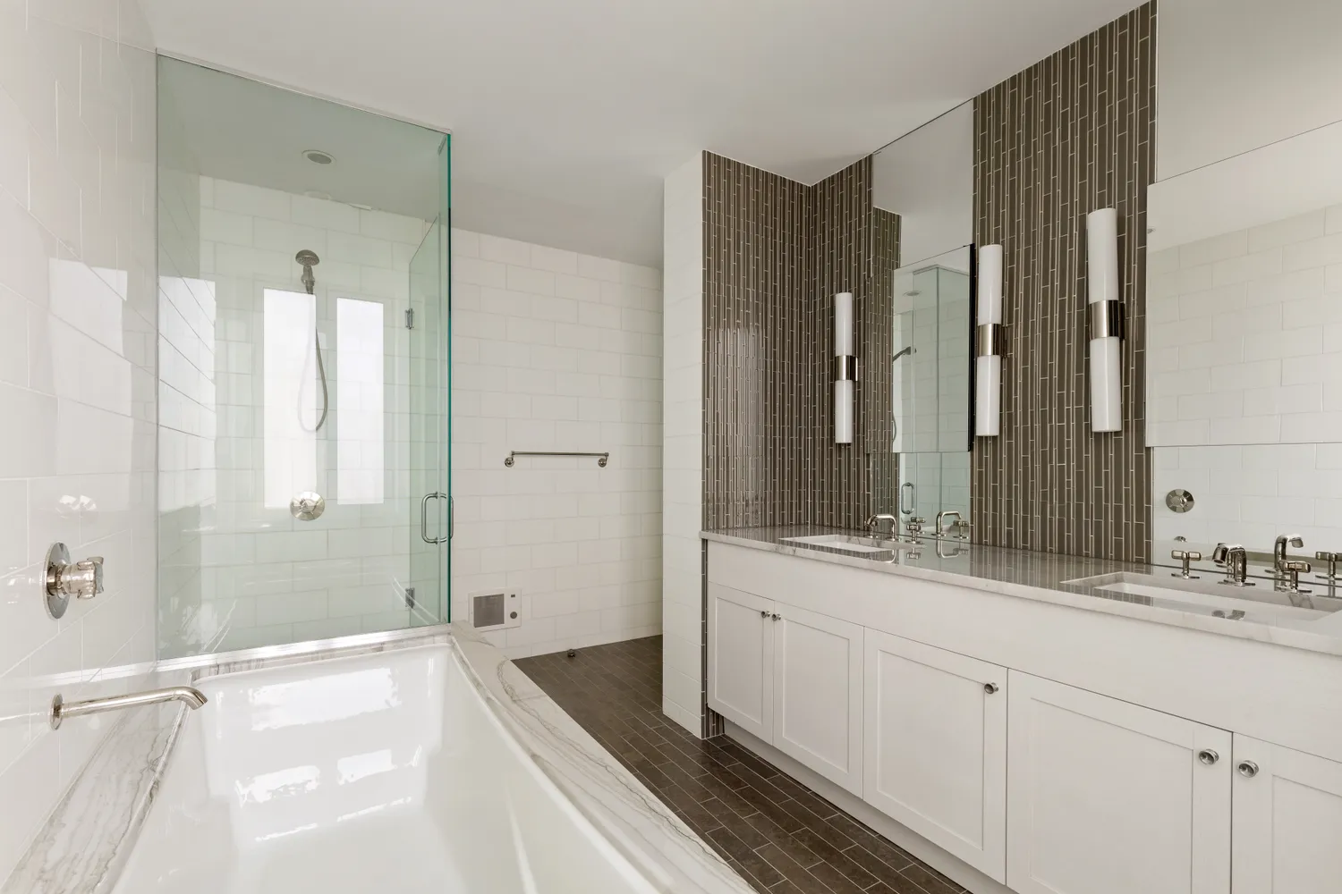 a spacious bathroom with a double vanity sink a large mirror a bathtub and shower