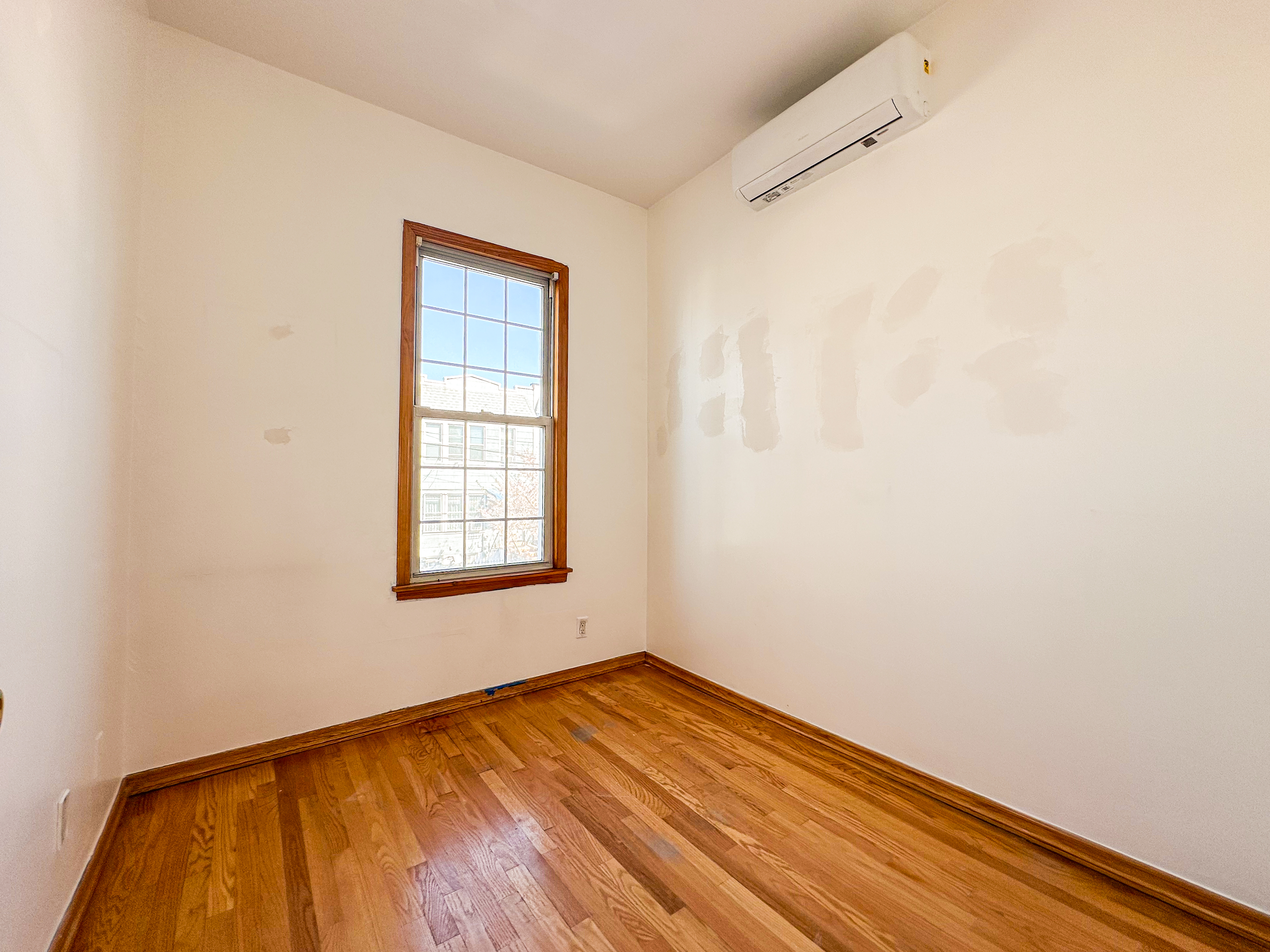 66-42 Clinton Avenue, Unit 2 Queens, NY 11378 - Photo 10 of 14 a view of empty room with wooden floor and fan