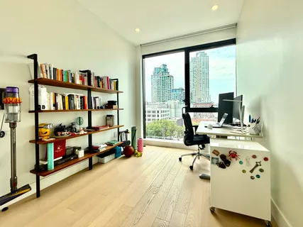 a view of a living room with furniture and floor to ceiling window