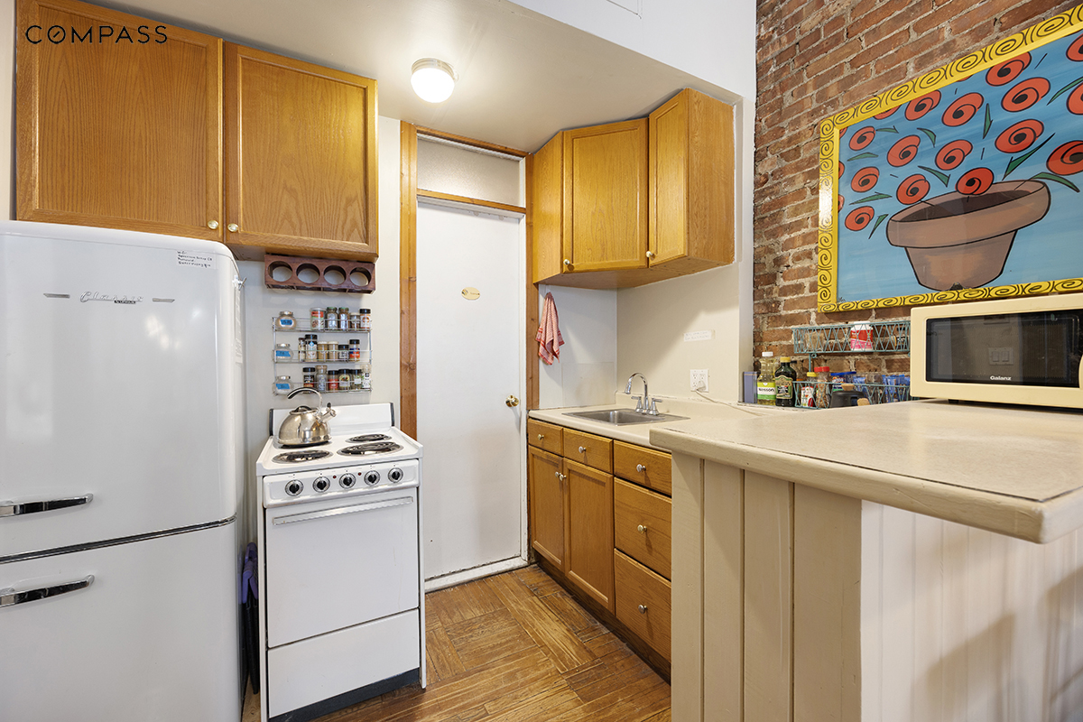 119 West 80th Street, Unit 2F Manhattan, NY 10024 - Photo 4 of 7 a kitchen with stainless steel appliances a stove a sink and a refrigerator
