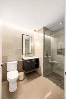 a bathroom with a bathtub shower sink mirror and toilet