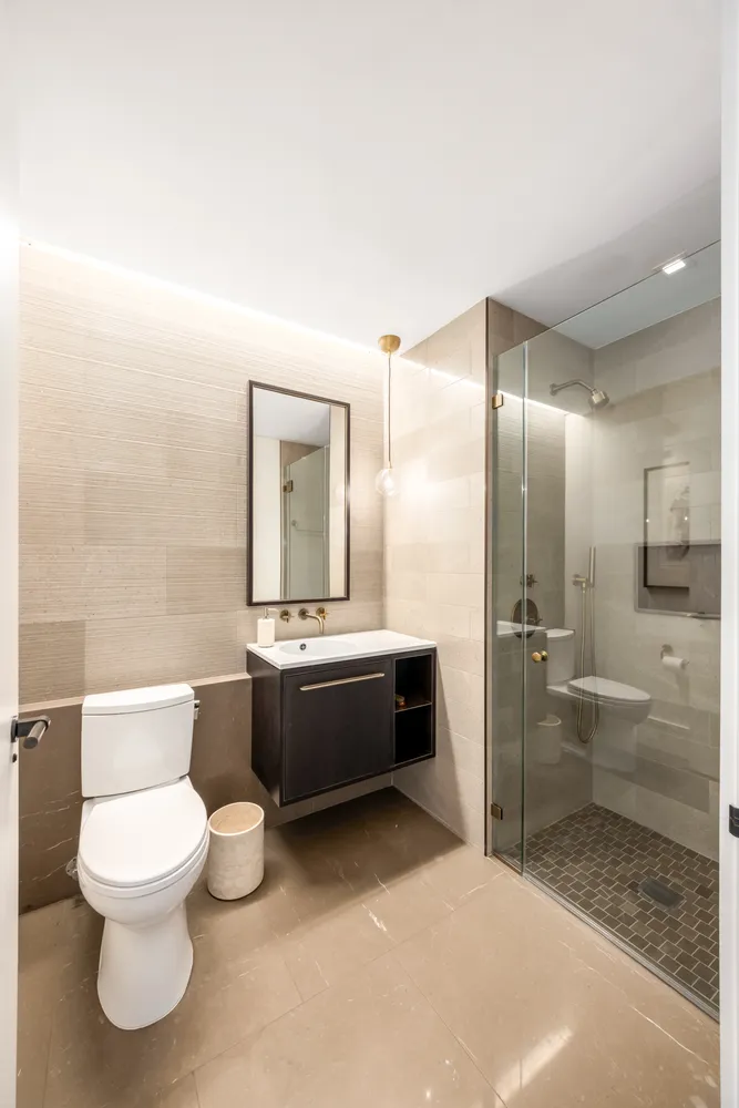 a bathroom with a bathtub shower sink mirror and toilet