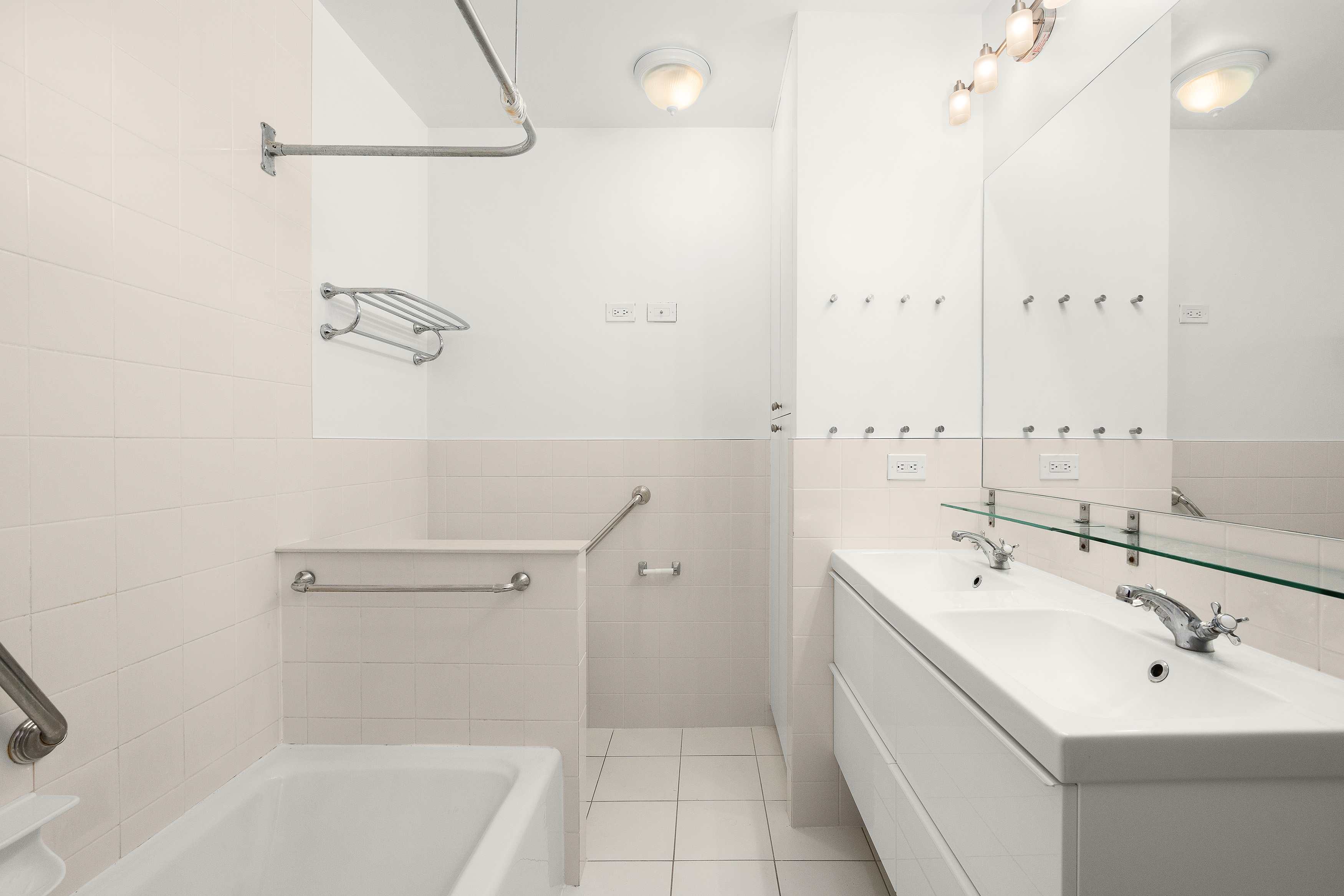 240 East 47th Street, Unit 4B Manhattan, NY 10017 - Photo 12 of 25 a bathroom with a bathtub a sink a toilet and a mirror