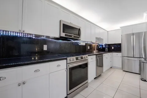 a kitchen with granite countertop a sink stainless steel appliances and cabinets