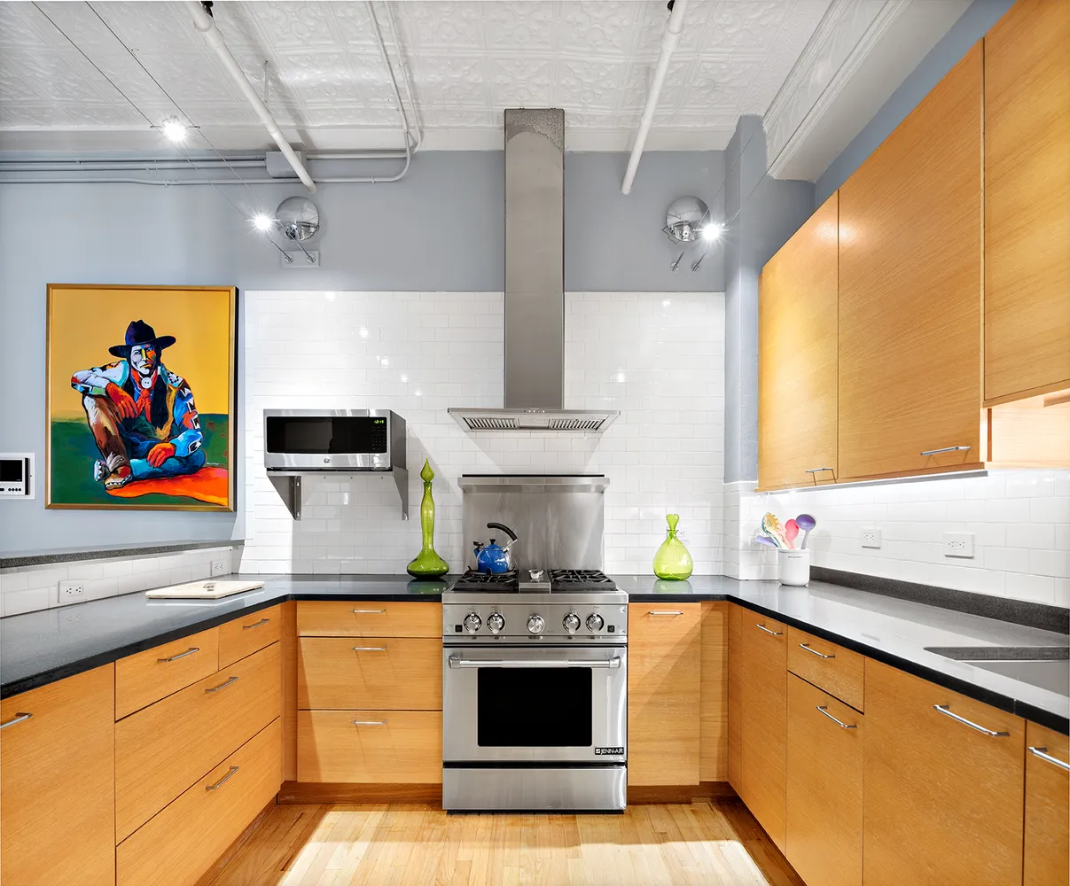 a kitchen with stainless steel appliances granite countertop a stove a sink and a microwave