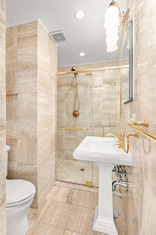 177 East 70th Street Manhattan, NY 10021 - Photo 9 of 14 a bathroom with a sink toilet and shower