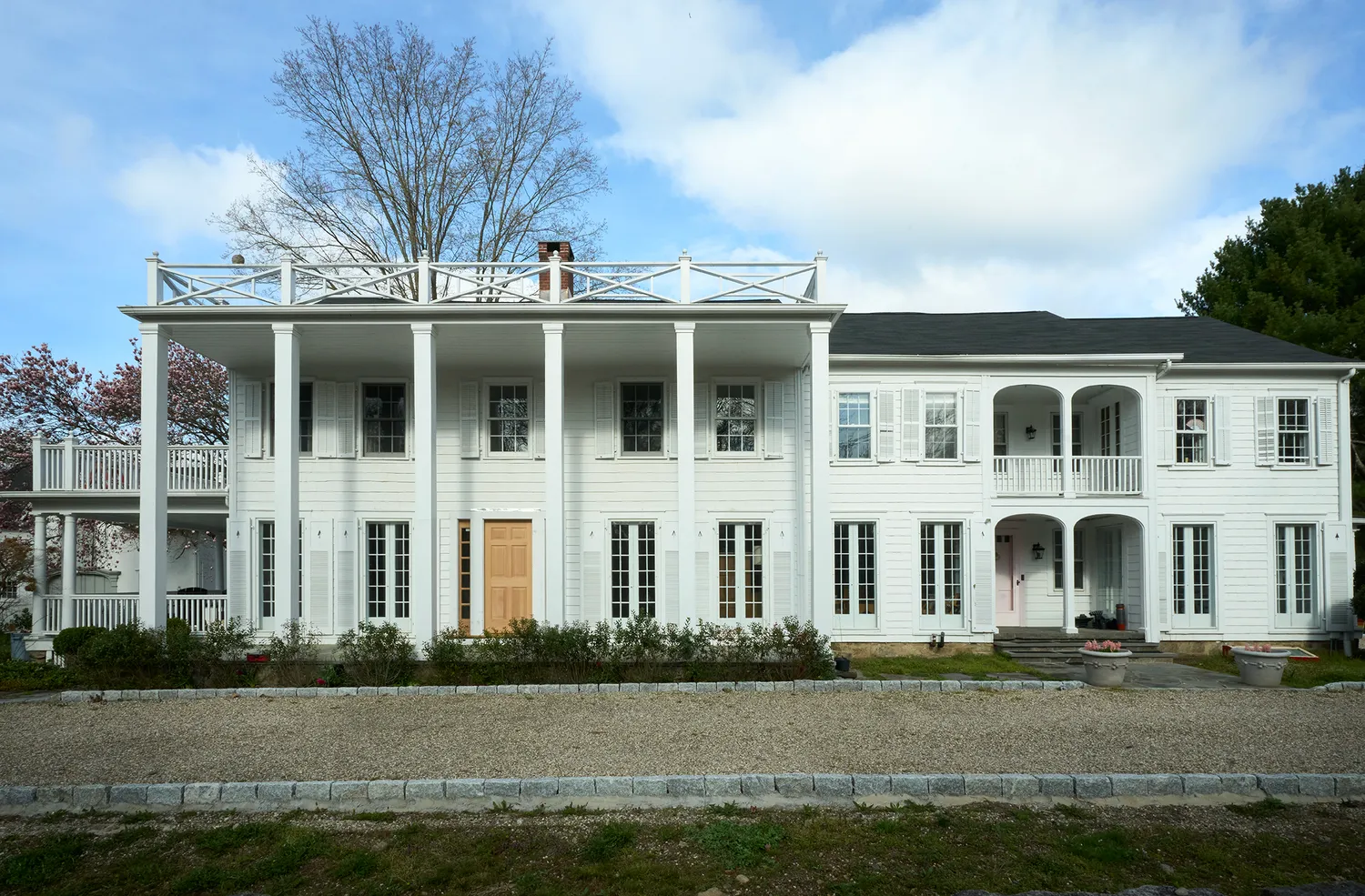 two large buildings with a big yard and large trees