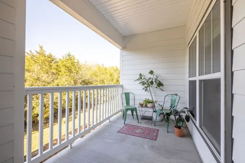 a view of a porch with chairs and backyard