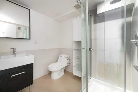 a bathroom with a toilet sink a mirror and shower