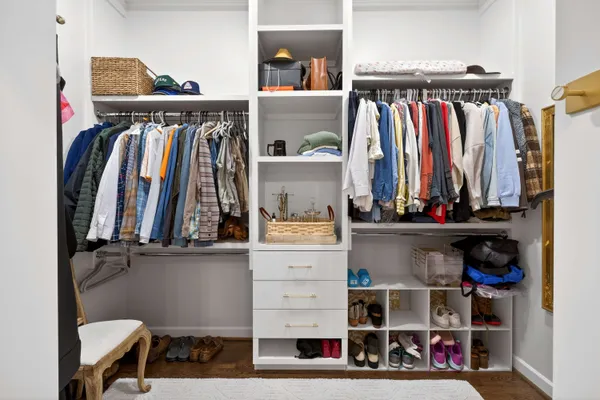 a view of walk in closet with clothes and shoes