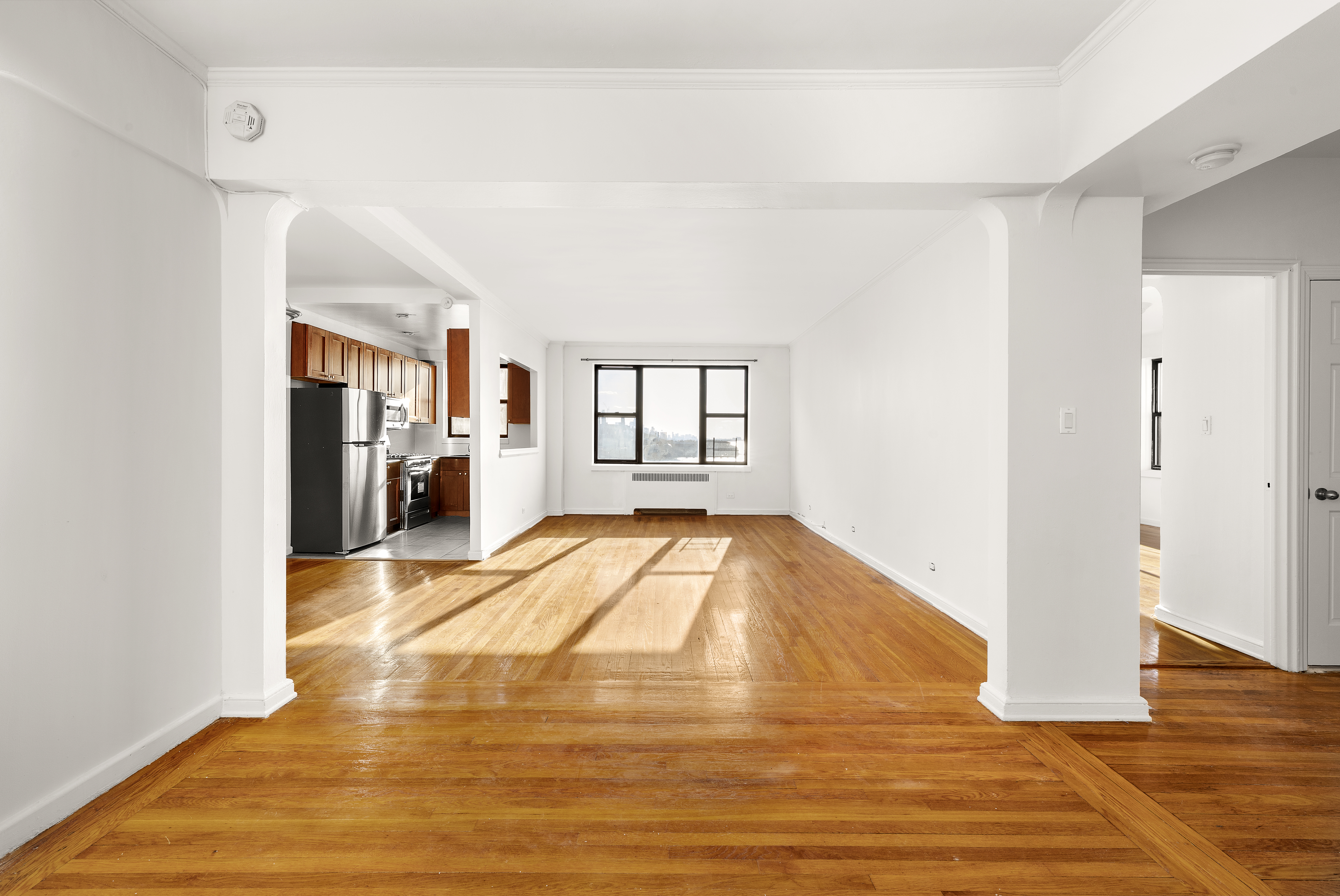 158-18 Riverside Drive West, Unit 4E50 Manhattan, NY 10032 - Photo 1 of 17 a view of empty room with wooden floor and fan