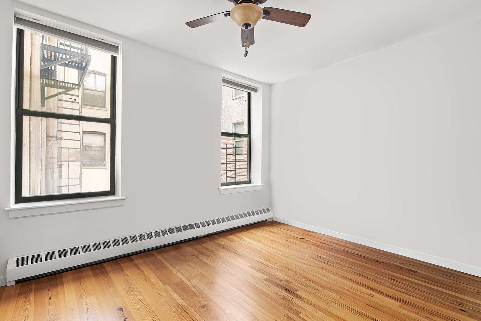 660 St Nicholas Avenue, Unit 54 Manhattan, NY 10030 - Photo 6 of 9 a view of an empty room with wooden floor and a window