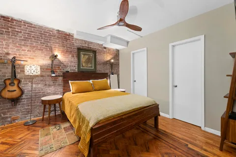a bedroom with bed and wooden floor